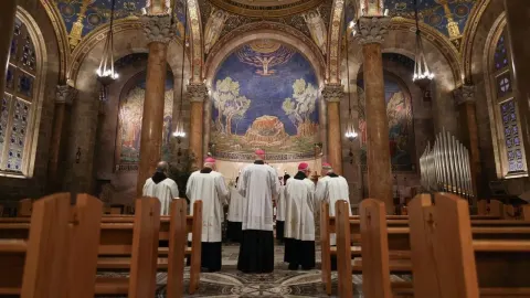 Svećenici u bijelim haljama mole ispred mozaika u Bazilici Agonije u Jeruzalemu.