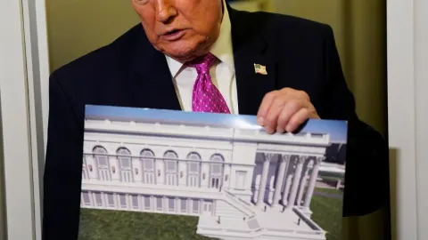 Donald Trump u odijelu drži ilustraciju Bijele kuće i novog podzemnog kompleksa