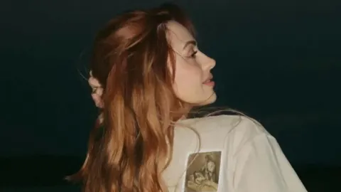 Albina Grčić s bakrenom bojom kose gleda u stranu