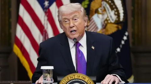 Donald Trump govori za govornicom ispred američke zastave