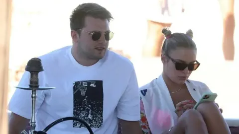 Luka Dončić i Anamarija Goltes sjede zajedno na otvorenom s naočalama za sunce.