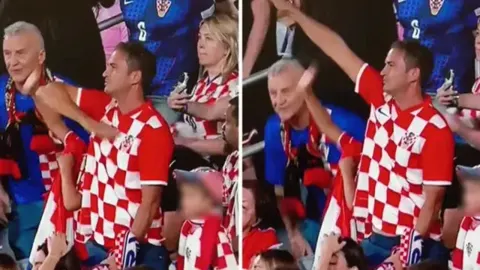 Muškarac u hrvatskom dresu s podignutom desnom rukom na stadionu