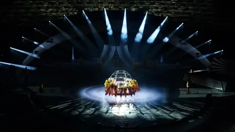 Svečana ceremonija otvaranja sportskog natjecanja pod reflektorima na velikoj pozornici.