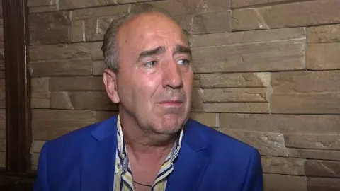 Mladen Grdović u suzama odijeva plavi sako i prugastu košulju