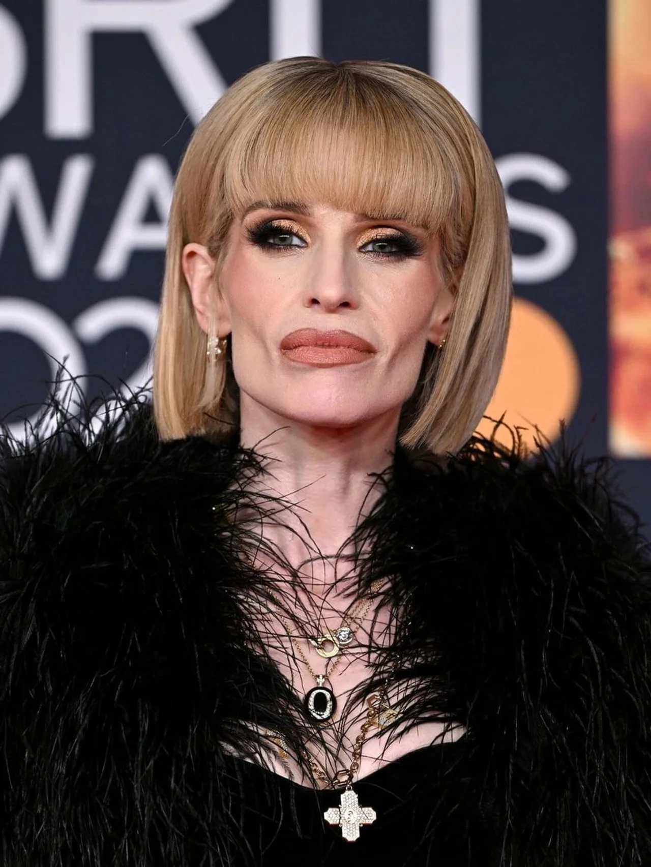 Portret Kelly Osbourne s plavom kosom i izraženim make-upom