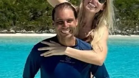 Nasmiješeni Rafael Nadal i supruga Mery Perelló na brodu ispred tirkiznog mora