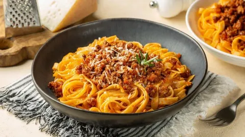 Tanjur tjestenine s bogatim bolonjez umakom i naribanim sirom