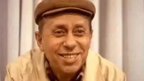 Portret nasmijanog glumca Miodraga Petrovića Čkalje s kapom na glavi.