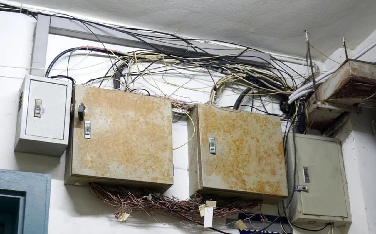 Zahrđale električne kutije i zapetljane instalacije na zidu