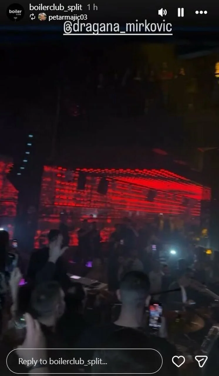 Gužva u zamračenom klubu s crvenim svjetlosnim efektima na stropu