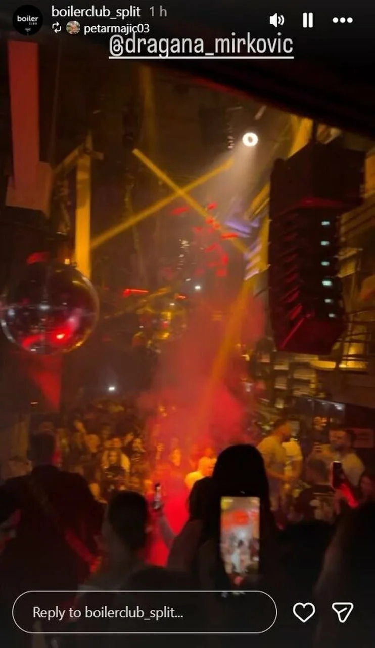 Pogled na publiku u klubu s mobitelima u rukama pod žutim reflektorima