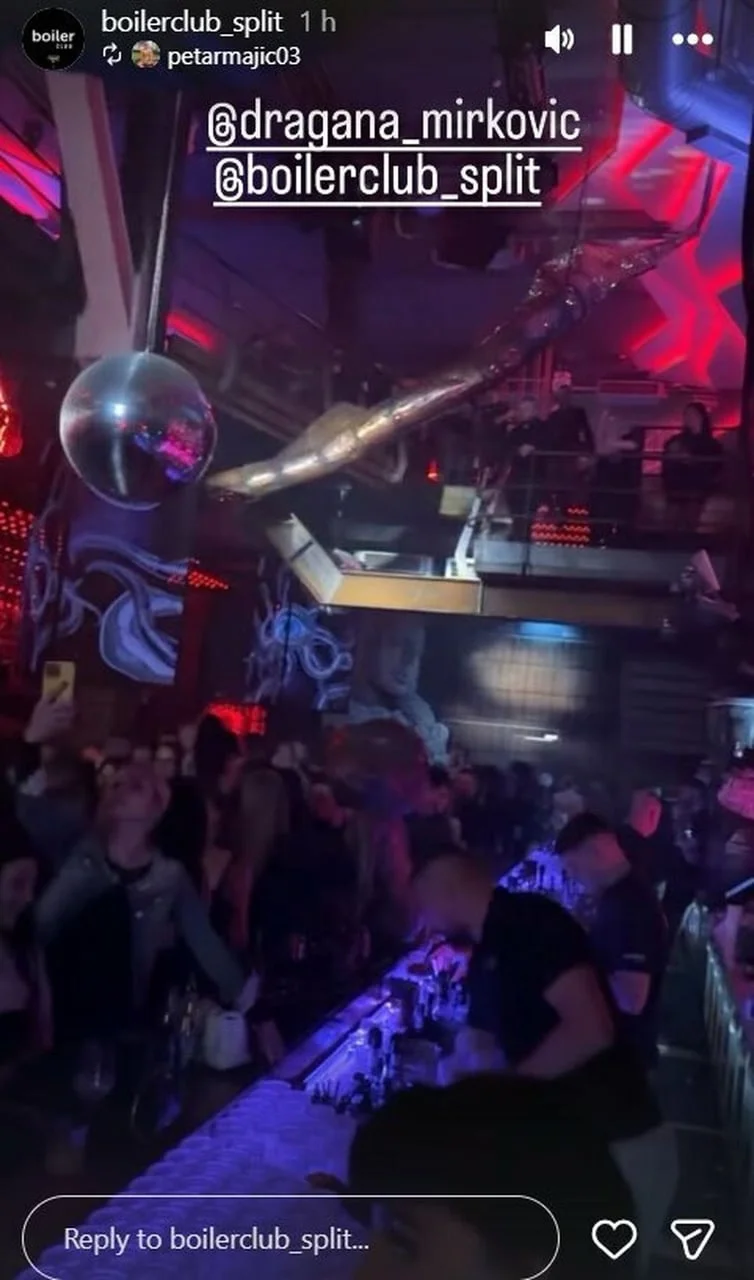 Šank u noćnom klubu s disko kuglom i ljudima u pozadini