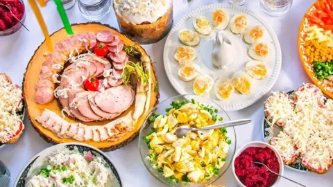 Raznovrsna blagdanska jela poslužena na bijelom stolnjaku