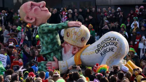 Velika karnevalska figura Putina i vjerskog poglavara pred mnoštvom ljudi