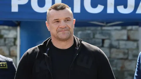 Mirko Filipović u crnoj sportskoj jakni stoji ispred plavog natpisa policije.