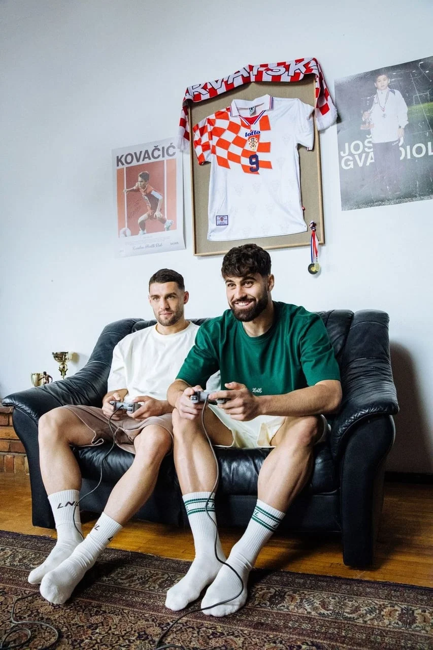 Kovačić i Gvardiol sjede na kauču i igraju videoigre u opuštenom izdanju.