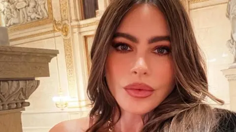 Portret Sofije Vergare s naglašenom šminkom u elegantnom interijeru