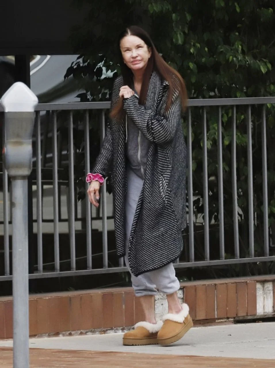 Portret Janice Dickinson u dugom ogrtaču na ulici.