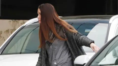 Janice Dickinson snimljena u opuštenom izdanju pored automobila.