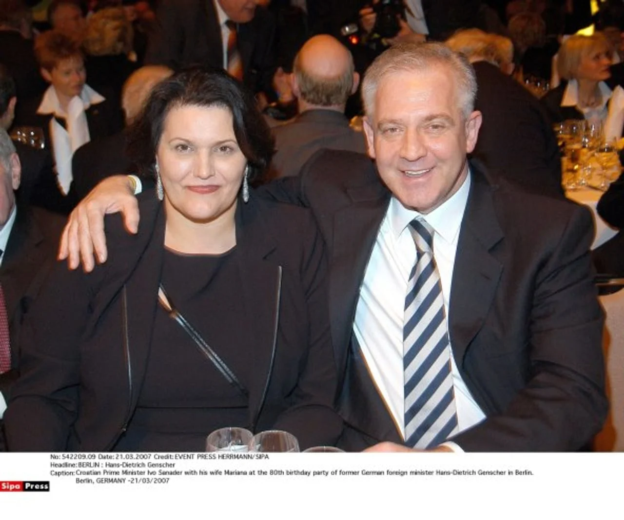 Muškarac i žena u svečanoj odjeći sjede za stolom na večeri.