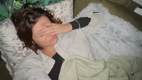 Ella Dvornik leži u krevetu s rukom preko lica