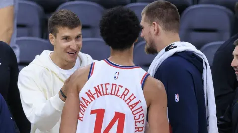 Bogdan Bogdanović i Nikola Jokić u razgovoru na košarkaškom terenu.