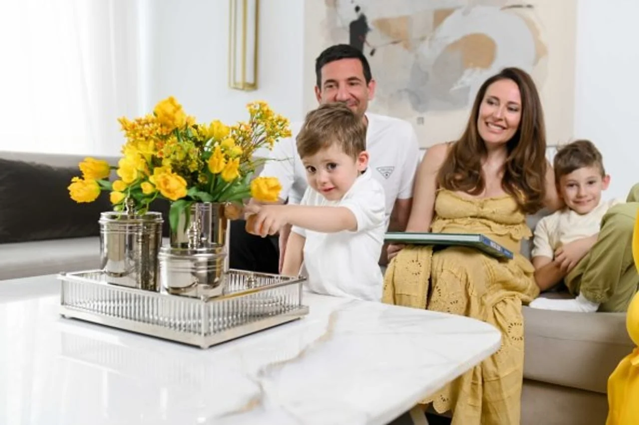 Mali dječak pokazuje žuto cvijeće na stolu