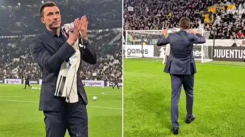 Mario Mandžukić u odijelu pozdravlja navijače na stadionu Juventusa u Torinu.