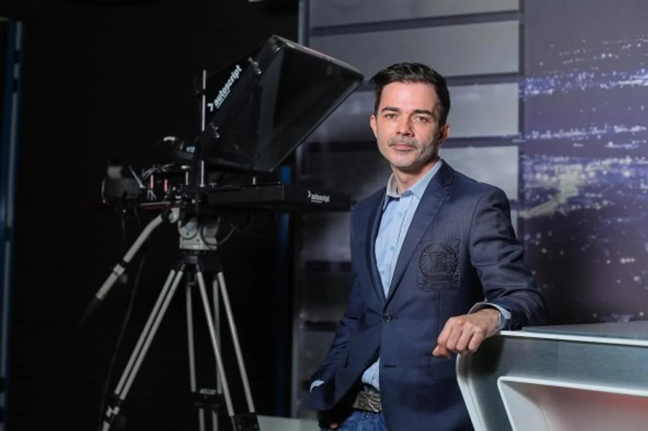 Daniel Delale u plavom sakou stoji u televizijskom studiju