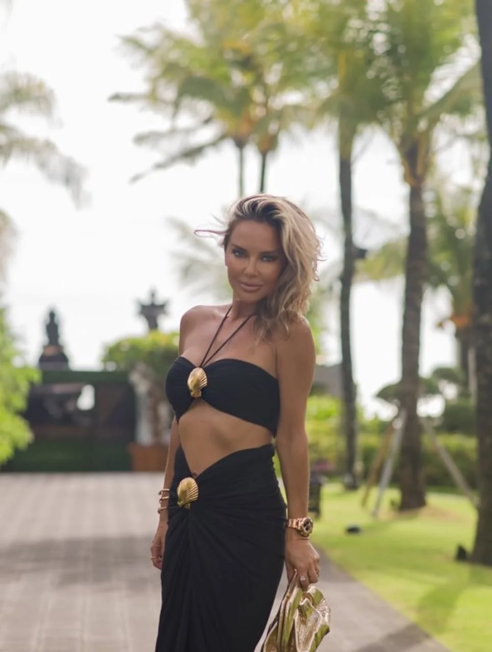 Maja Šuput u crnom dvodijelnom kompletu na tropskoj lokaciji