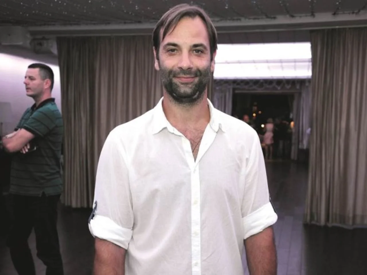 Ivano Balić s bradom u bijeloj košulji nasmijan pozira u zatvorenom prostoru