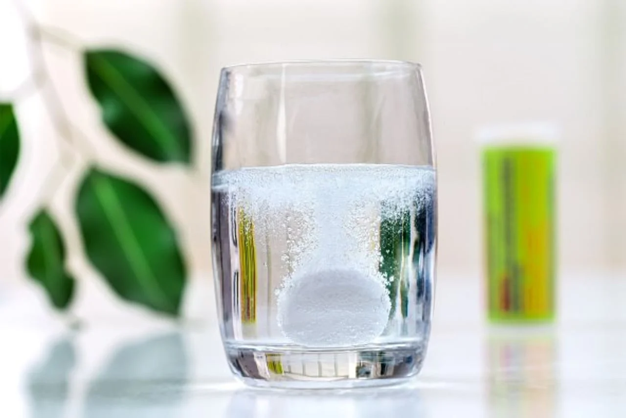 Šumeća tableta otapa se u čaši vode stvarajući mjehuriće.