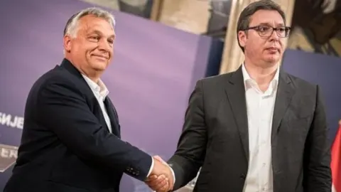 Viktor Orban i Aleksandar Vučić rukuju se ispred ljubičaste pozadine