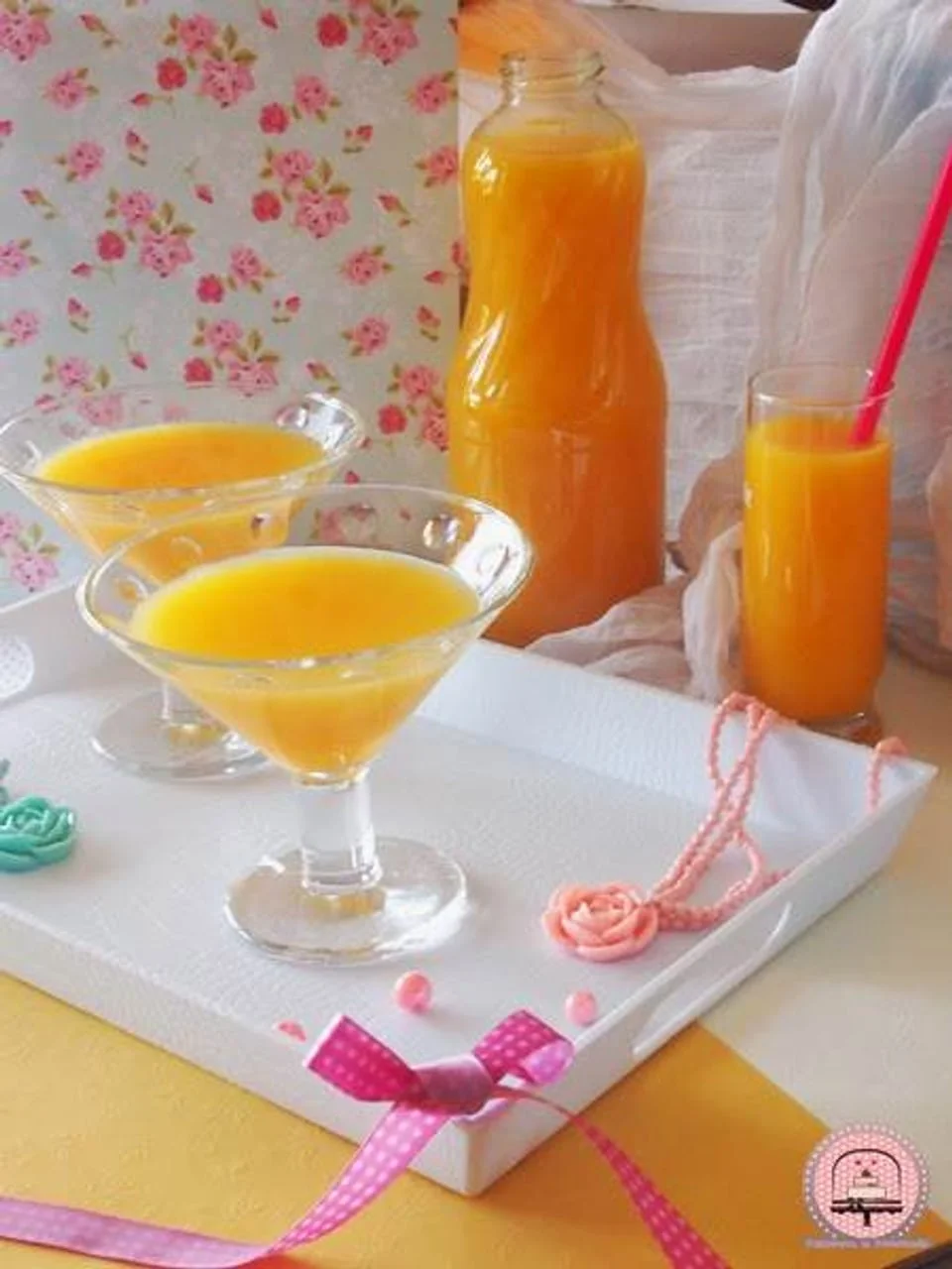 Sok od naranče u staklenoj boci i čašama na bijelom pladnju