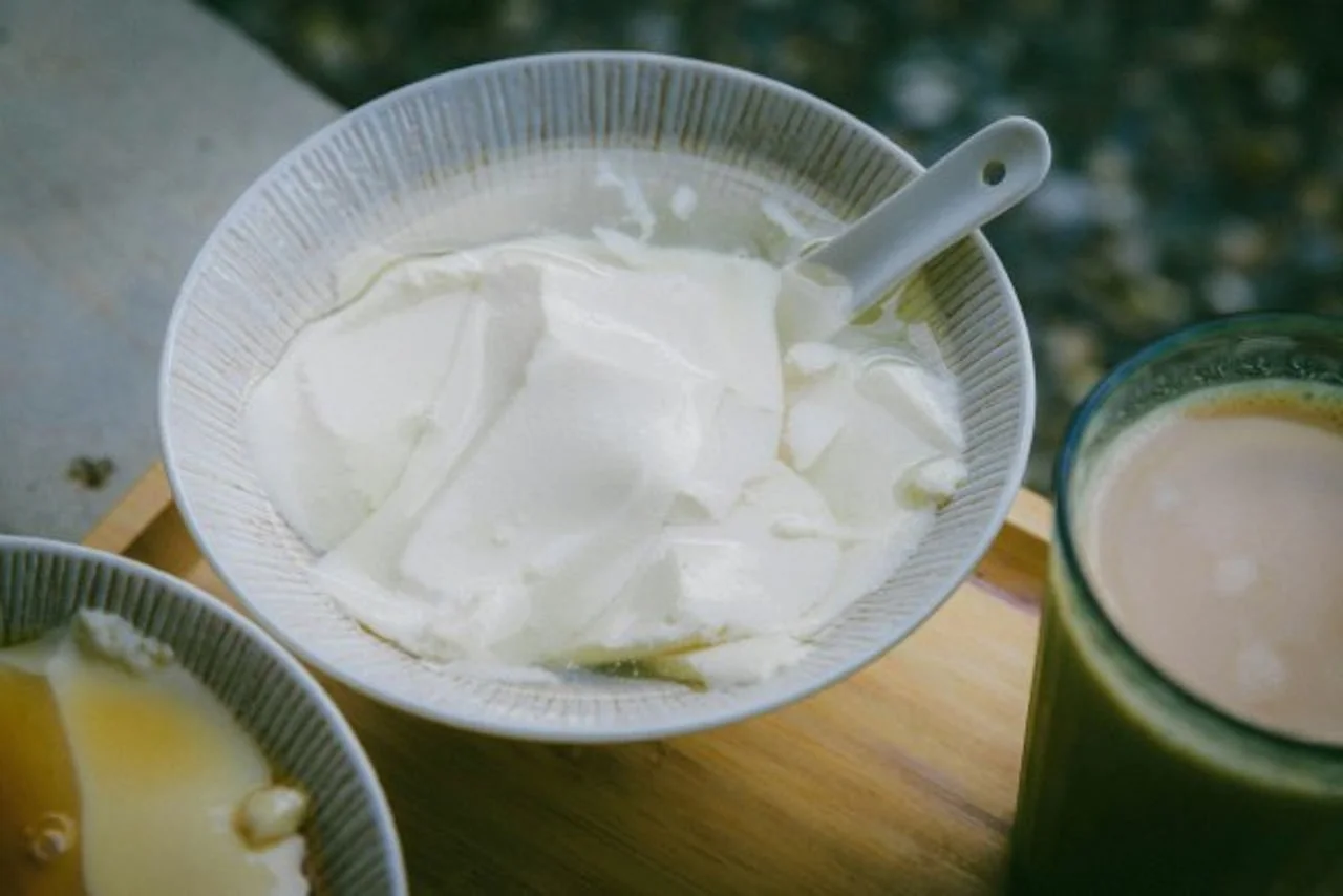 Bijeli kremasti desert u zdjelici pored napitka