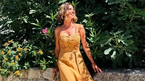 Bojana Gregorić Vejzović u žutoj ljetnoj haljini ispred zelenila