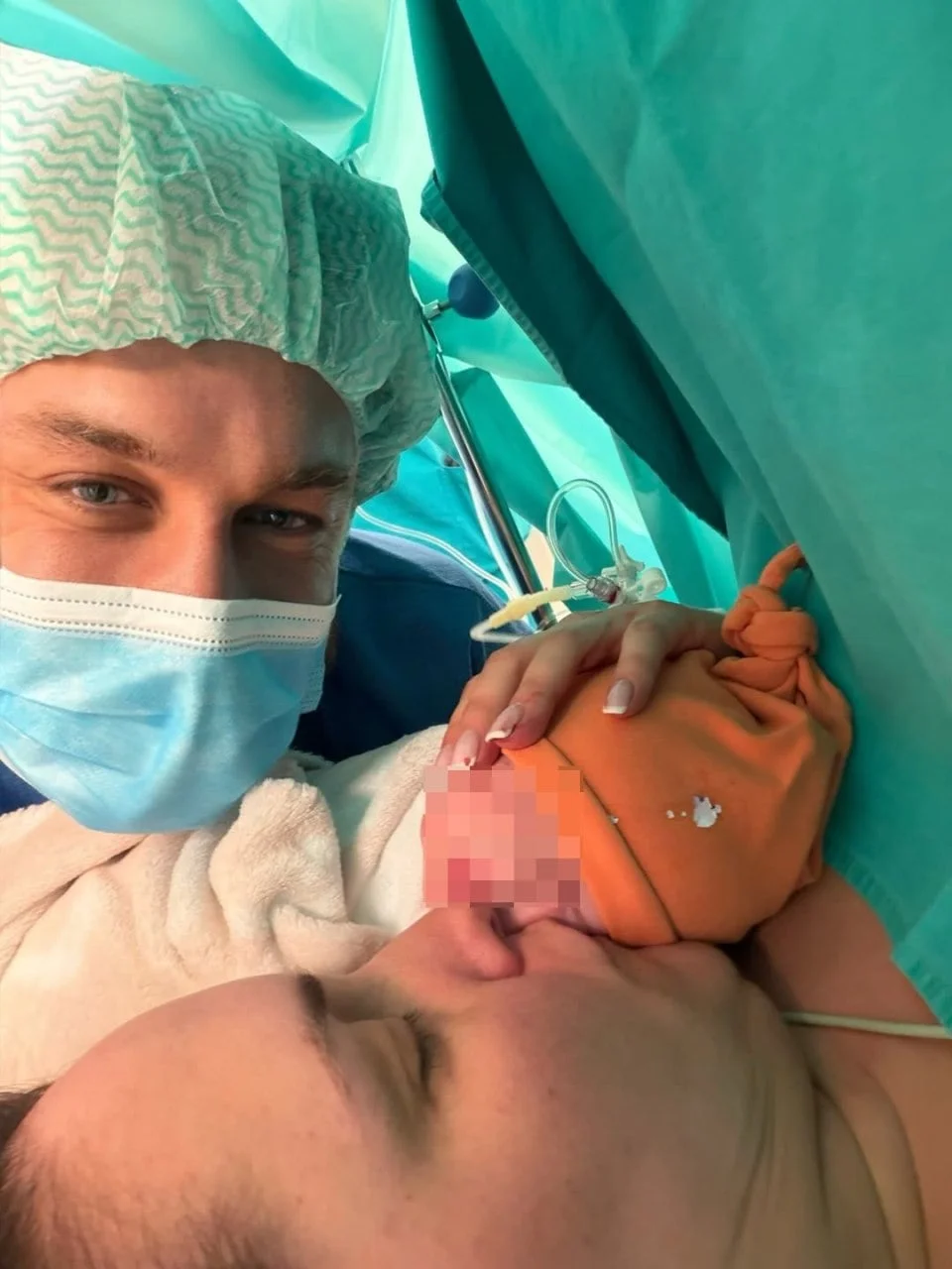 Krupni kadar roditelja s novorođenom bebom u bolničkom okruženju.