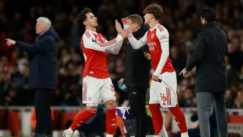 Igrači Arsenala na rubu terena tijekom zamjene, Mikel Arteta stoji u pozadini.