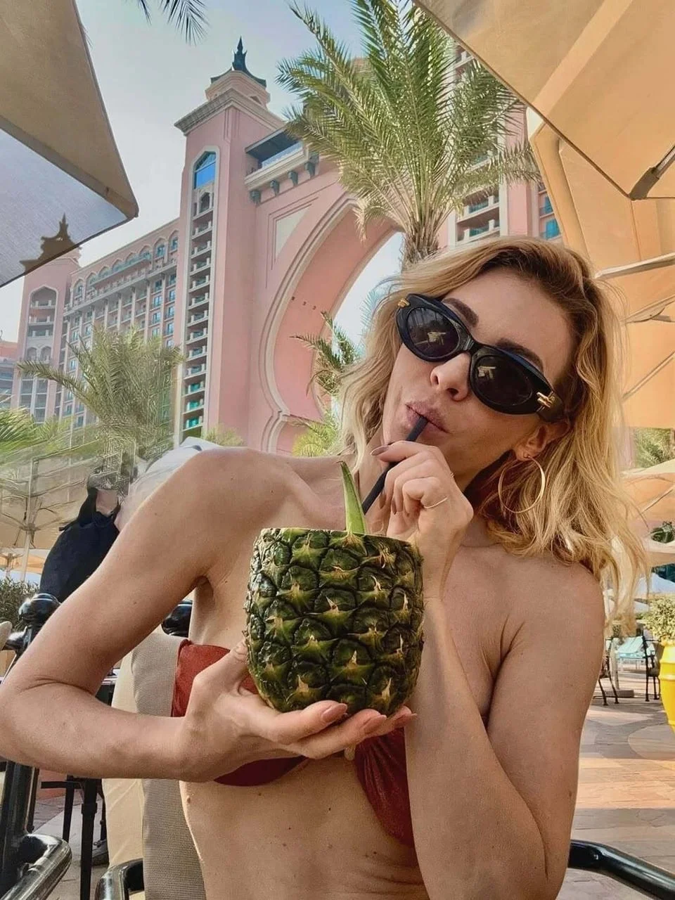 Anja Alavanja Viljevac pije koktel iz ananasa na egzotičnoj lokaciji