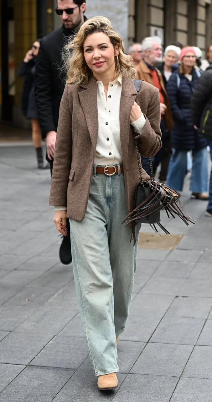 Cijela figura voditeljice u modernoj odjevnoj kombinaciji na ulici