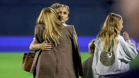 Luka Modrić u zagrljaju sa suprugom i kćerima na nogometnom terenu.