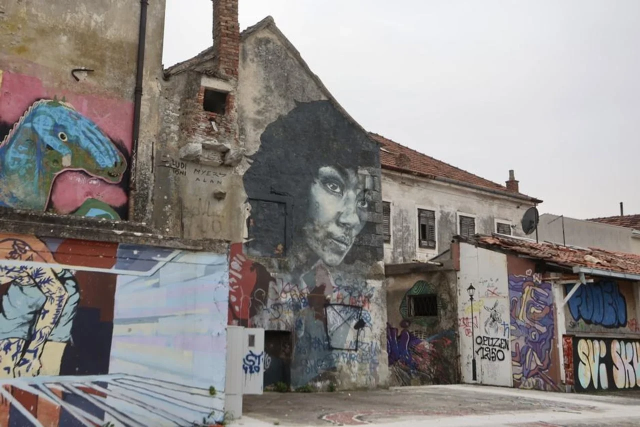 Zidovi starih zgrada prekriveni modernim grafitima i muralima.