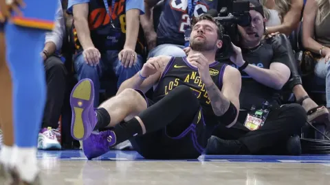 Luka Dončić sjedi na parketu s bolnim izrazom lica tijekom NBA utakmice