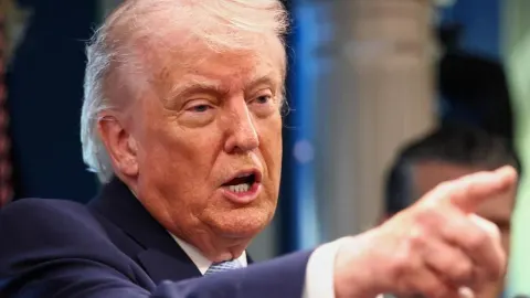 Donald Trump u krupnom planu dok govori i prstom pokazuje prema naprijed