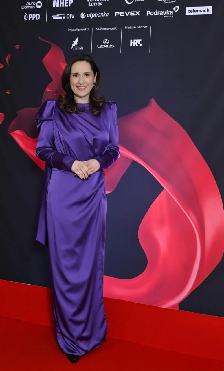 Petra Škrobot u dugoj ljubičastoj haljini pozira na crvenom tepihu ispred sponzorskog zida.