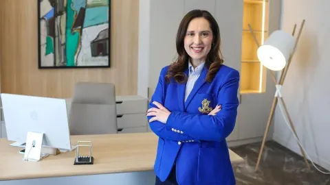 Petra Škrobot u plavom sakou stoji prekriženih ruku u moderno uređenom uredu.