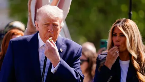Donald i Melania Trump pušu u zviždaljke na otvorenom prostoru.