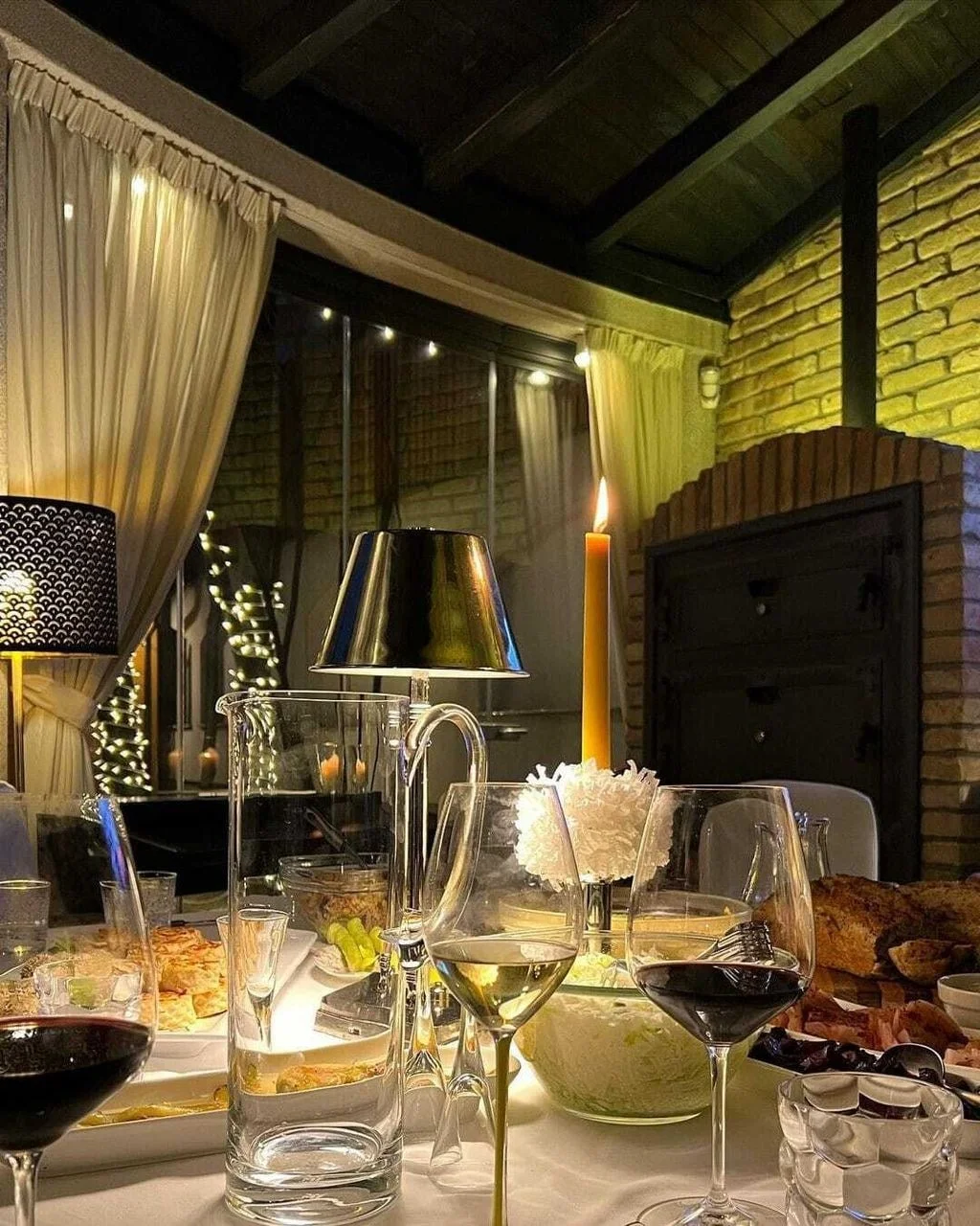 Postavljen blagdanski stol s vinom i svijećom u ambijentalnom prostoru