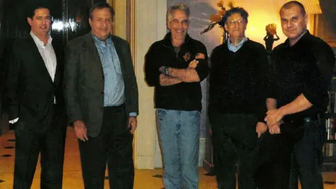 Bill Gates i Jeffrey Epstein stoje s grupom muškaraca u zatvorenom prostoru.