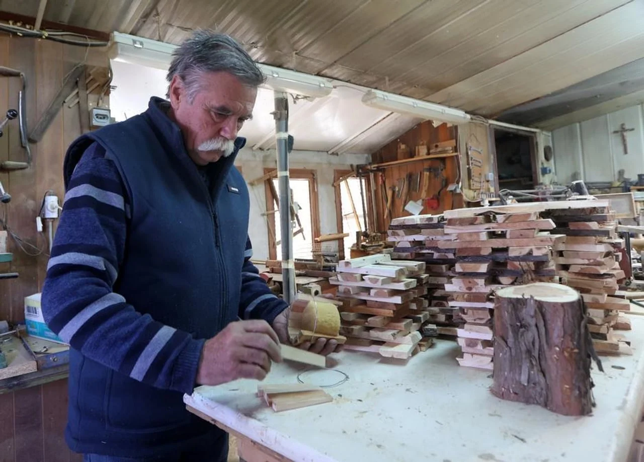 Majstor stolar precizno sastavlja komade drveta za izradu tradicionalne posude.
